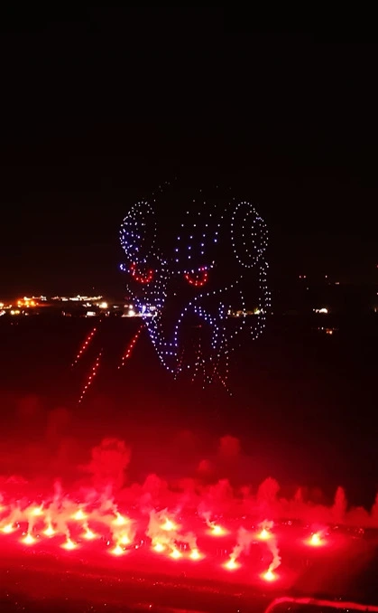 Drones in a formation of Robot Head shooting lasers from its eyes